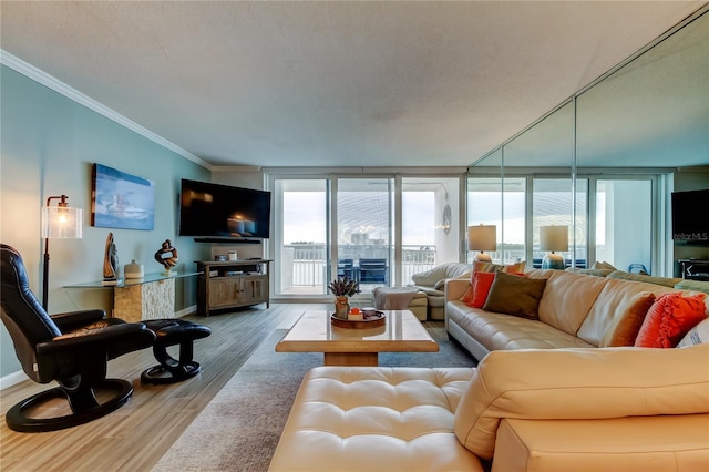 living room with wood-type flooring, a wall of windows, and crown molding