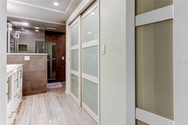 bathroom with a shower with shower door, wood-type flooring, and vanity