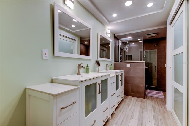 bathroom featuring a tray ceiling, hardwood / wood-style floors, an enclosed shower, and vanity