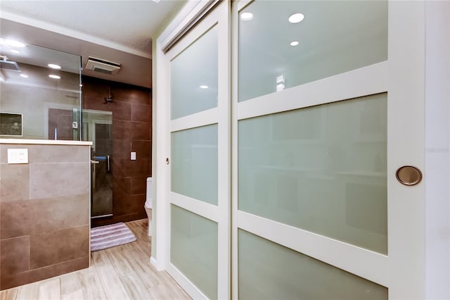 bathroom featuring toilet, hardwood / wood-style floors, and an enclosed shower