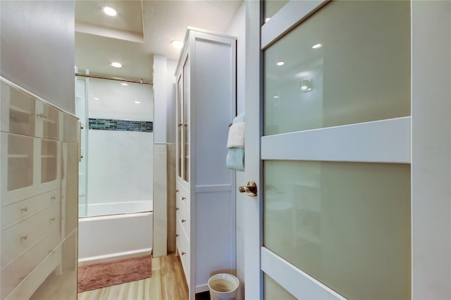 bathroom with combined bath / shower with glass door and hardwood / wood-style flooring