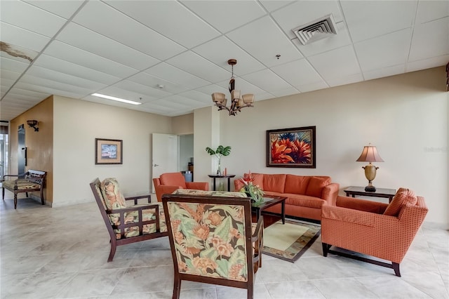 living room with an inviting chandelier and a paneled ceiling