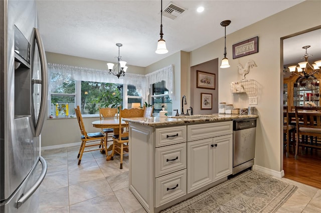 kitchen with appliances with stainless steel finishes, a chandelier, decorative light fixtures, and sink