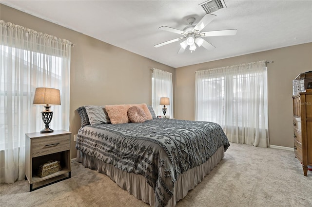 carpeted bedroom with ceiling fan and multiple windows