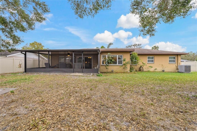 back of property with a sunroom, a lawn, and central air condition unit