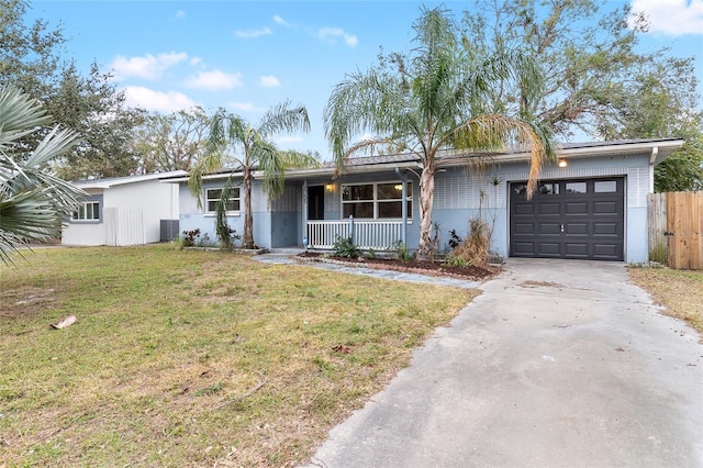 ranch-style house with central AC unit, a garage, a front lawn, and covered porch