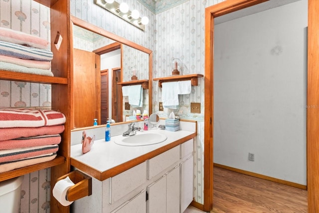 bathroom with toilet, vanity, and hardwood / wood-style floors