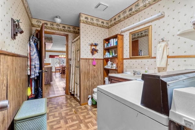 laundry room featuring sink, separate washer and dryer, an inviting chandelier, and light parquet flooring