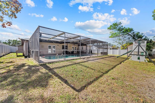 view of yard featuring a patio area, glass enclosure, a playground, a fenced backyard, and a fenced in pool