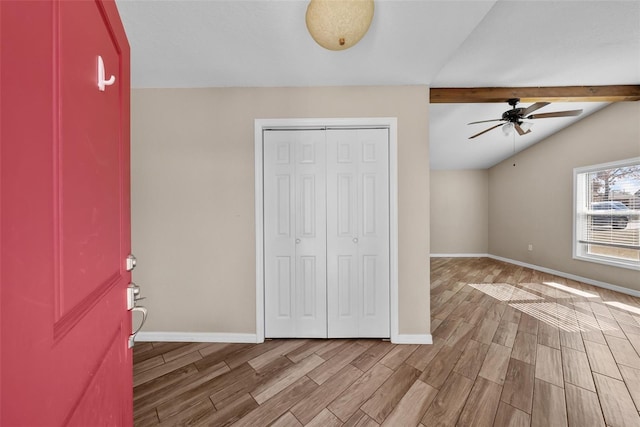 unfurnished bedroom featuring baseboards, wood finished floors, and a closet