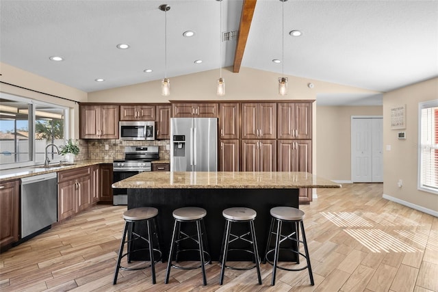 kitchen with lofted ceiling with beams, stainless steel appliances, a center island, a sink, and tasteful backsplash