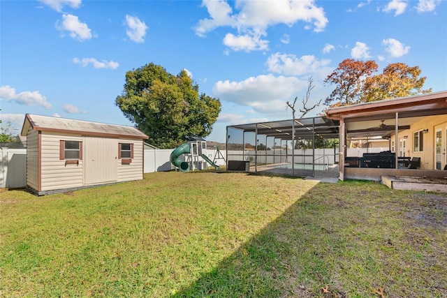 view of yard featuring an outbuilding, a fenced backyard, a playground, a hot tub, and a patio