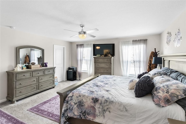 bedroom with light colored carpet, a textured ceiling, and ceiling fan