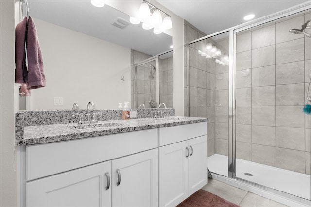 bathroom featuring tile patterned flooring, vanity, and a shower with shower door