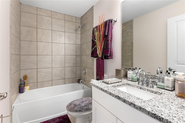 full bathroom featuring vanity, tiled shower / bath combo, and toilet