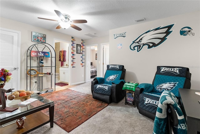 interior space with ceiling fan, light colored carpet, and a textured ceiling