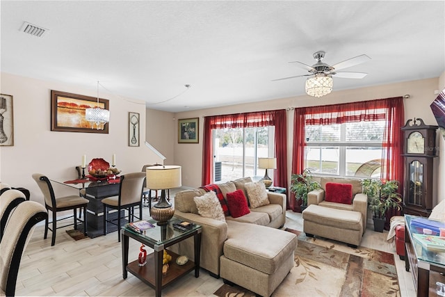 living room with a wealth of natural light, ceiling fan, and light hardwood / wood-style flooring