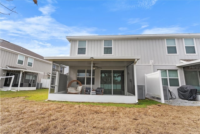 back of property with cooling unit, a yard, a sunroom, and ceiling fan