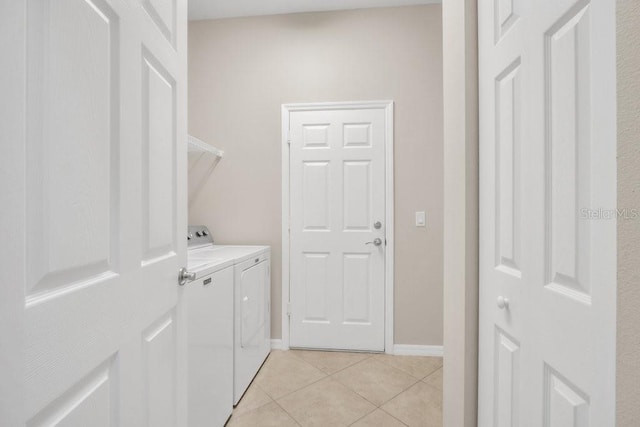 laundry area with independent washer and dryer and light tile patterned flooring