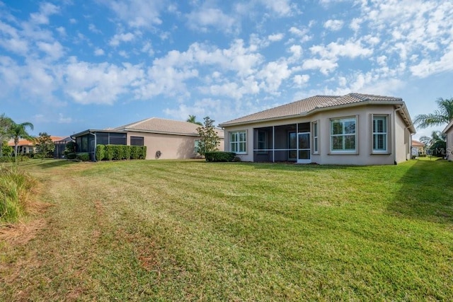 back of house with a sunroom and a yard