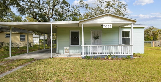 view of front facade featuring a porch, a carport, and a front lawn