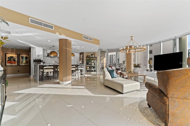 living room featuring decorative columns, a wall of windows, a notable chandelier, and light tile patterned flooring