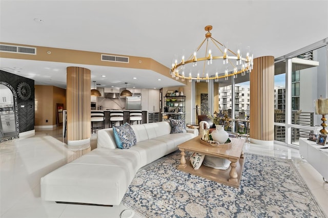 living room with light tile patterned floors, a wall of windows, and a notable chandelier