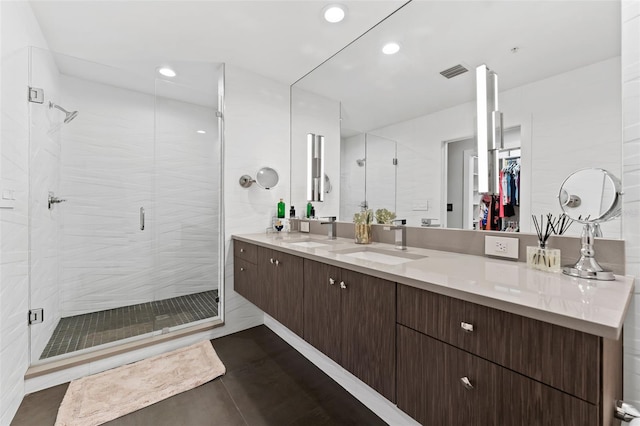 bathroom with tile patterned floors, walk in shower, and vanity