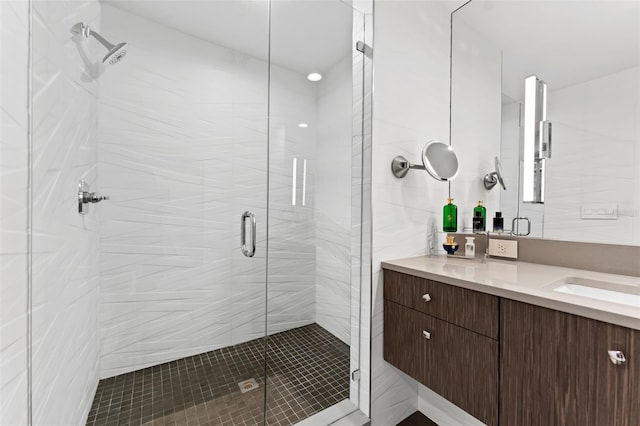 bathroom featuring tile walls, walk in shower, and vanity