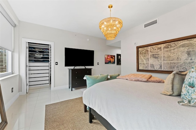 bedroom with light tile patterned floors and an inviting chandelier