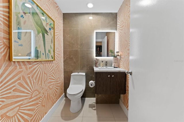 bathroom featuring toilet, tile patterned flooring, tile walls, and vanity