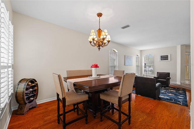 dining area with hardwood / wood-style flooring and a notable chandelier