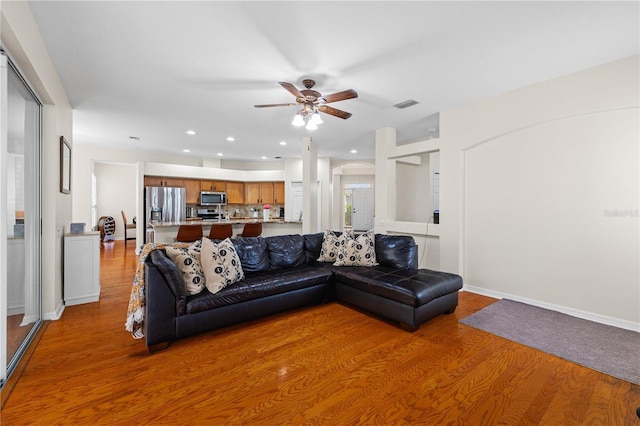 living room featuring light hardwood / wood-style flooring and ceiling fan