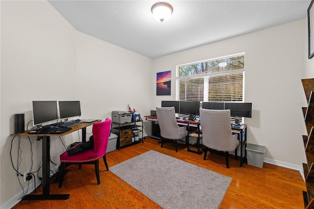 home office featuring wood-type flooring and a textured ceiling