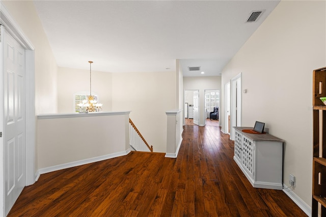 hallway featuring an inviting chandelier and dark hardwood / wood-style floors