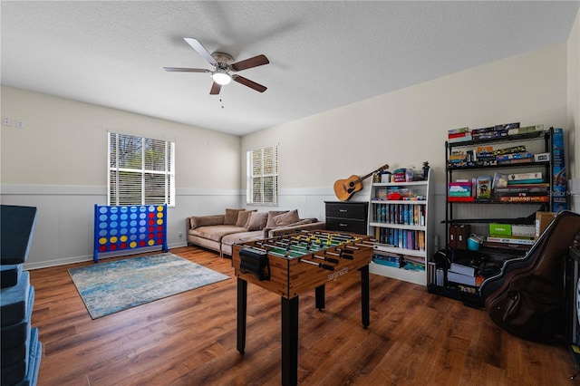 playroom with ceiling fan, hardwood / wood-style floors, and a textured ceiling