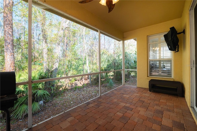 unfurnished sunroom with ceiling fan