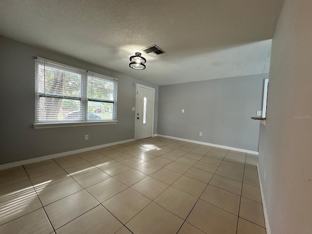 tiled foyer entrance with a textured ceiling