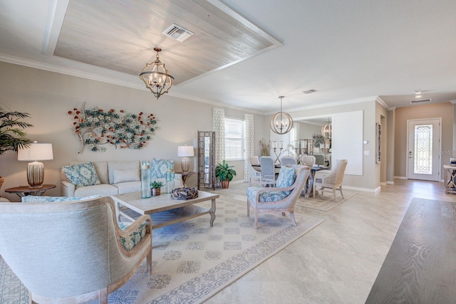 living room featuring a tray ceiling, ornamental molding, and a chandelier