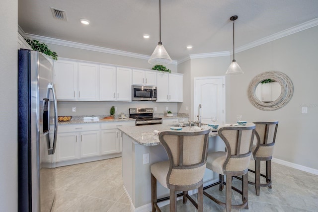 kitchen with stainless steel appliances, white cabinetry, a center island with sink, and decorative light fixtures