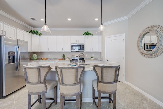 kitchen featuring sink, a kitchen island with sink, stainless steel appliances, white cabinets, and decorative light fixtures