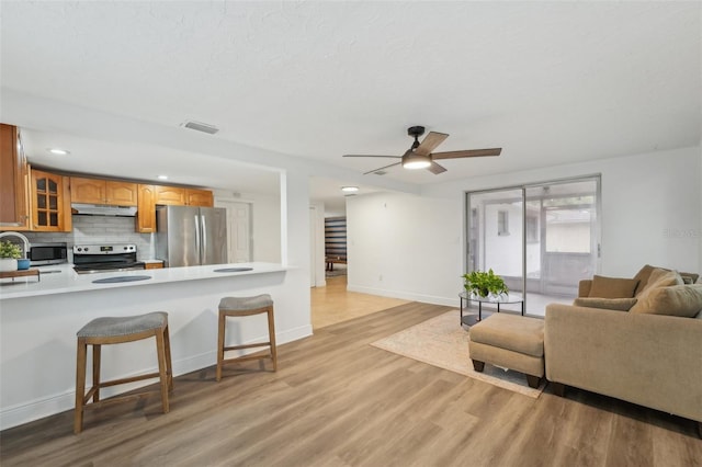 living room with ceiling fan and light wood-type flooring