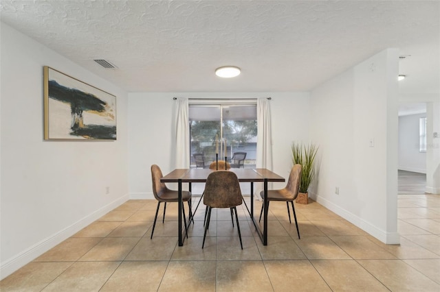 dining room featuring light tile patterned floors and a textured ceiling