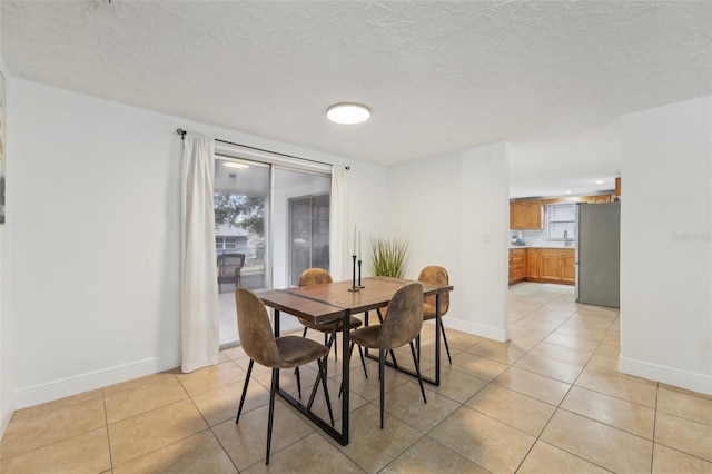 tiled dining area with a textured ceiling