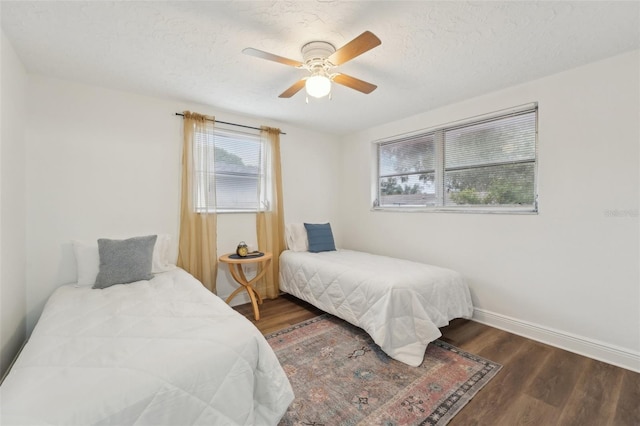 bedroom featuring a textured ceiling, ceiling fan, and dark hardwood / wood-style flooring