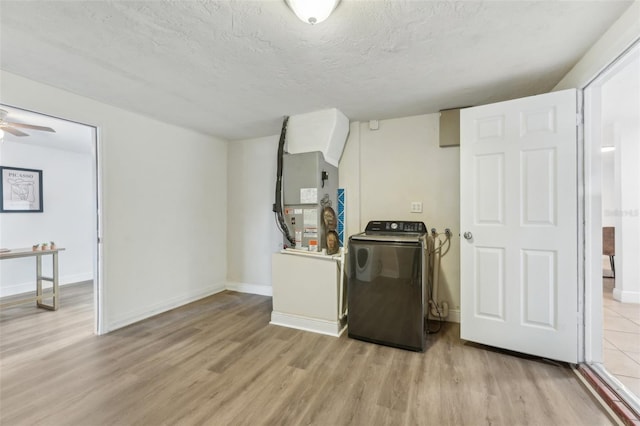 washroom featuring ceiling fan, washer / clothes dryer, a textured ceiling, heating unit, and light hardwood / wood-style floors