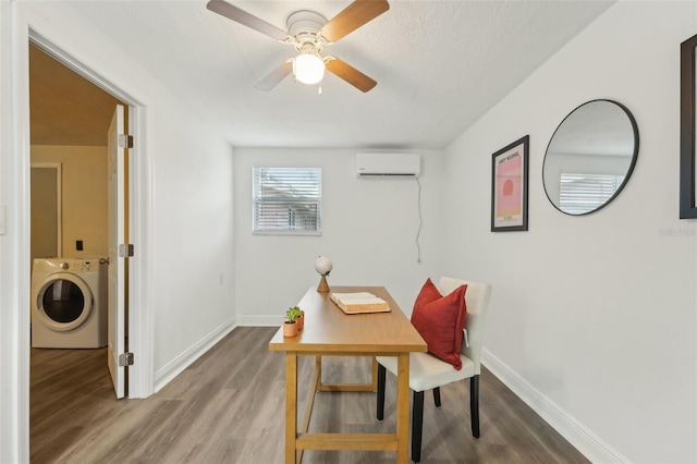 home office with a wall mounted air conditioner, washer / dryer, ceiling fan, and hardwood / wood-style flooring