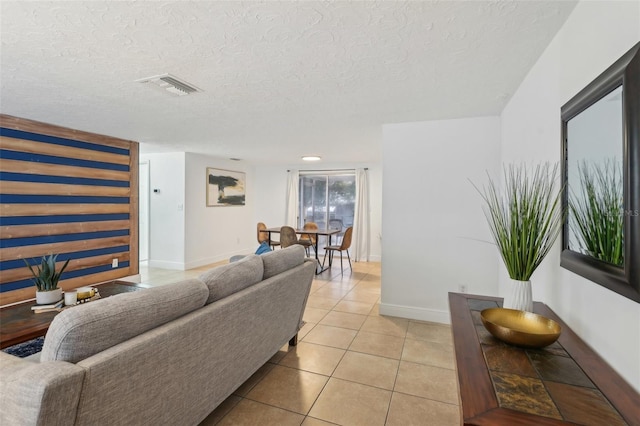 tiled living room featuring a textured ceiling