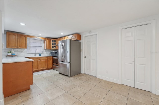 kitchen with sink, stainless steel appliances, tasteful backsplash, and light tile patterned flooring