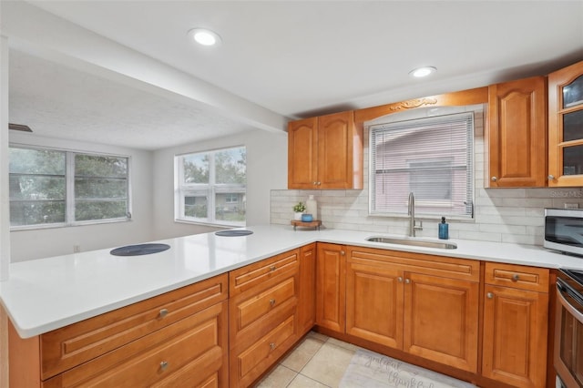 kitchen featuring decorative backsplash, sink, plenty of natural light, and kitchen peninsula